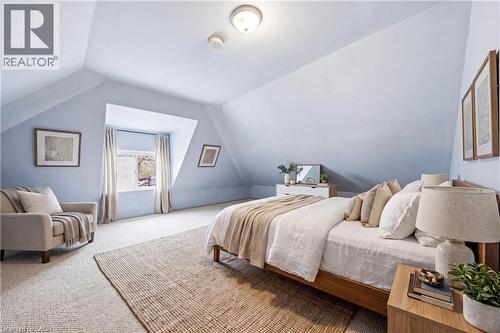 Spacious bedroom featuring vaulted ceilings, light blue wall finishes, and a window dormer - 30 Grand Avenue, Caledonia, ON 