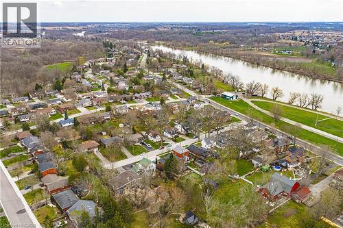 Aerial view showcasing the residential area with a prominent river, extensive green spaces, and a paved road running parallel to the river - 30 Grand Avenue, Caledonia, ON 