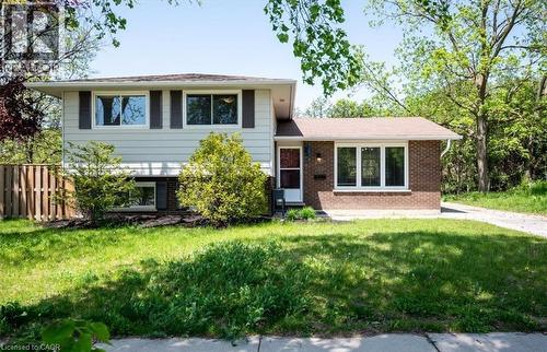 The property features a combination of white siding and brick exterior, with a brown shingle roof - 152 Macgregor Crescent, Waterloo, ON - Outdoor