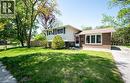 The property features a brick and siding exterior with a pitched roof, a front door with a storm door, and a well-maintained lawn with mature trees - 152 Macgregor Crescent, Waterloo, ON  - Outdoor 