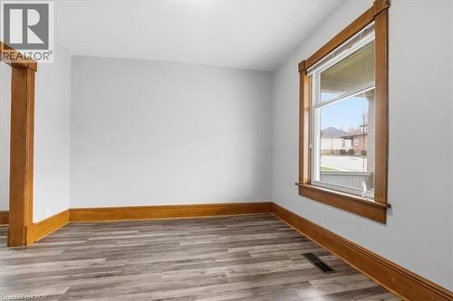 The room features light gray walls, wood trim around the window and doorways, and gray flooring - 12 Todd Street, Cambridge, ON - Indoor Photo Showing Other Room