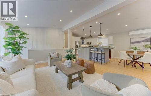This living space features light wood flooring, recessed lighting, and a kitchen island with pendant lights - 400 Manchester Road, Kitchener, ON - Indoor Photo Showing Living Room