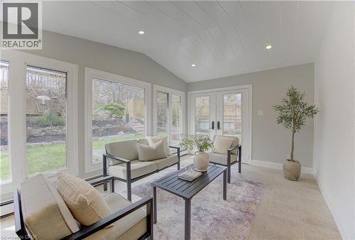 This sunroom features a vaulted ceiling with recessed lighting, large windows, and a set of double doors providing direct access to the outdoor area - 400 Manchester Road, Kitchener, ON - Indoor Photo Showing Living Room