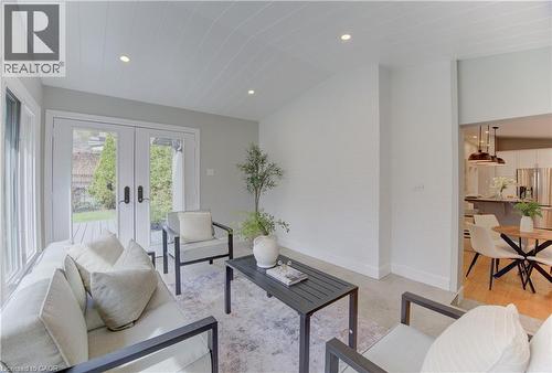 Inviting living area featuring a decorative ceiling, recessed lighting, and double glass doors opening to a deck and green space - 400 Manchester Road, Kitchener, ON - Indoor Photo Showing Living Room