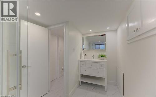 Bathroom featuring a white vanity with drawers and an open shelf, a wall-mounted mirror, and recessed lighting - 400 Manchester Road, Kitchener, ON - Indoor Photo Showing Bathroom