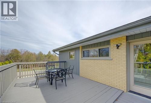 The property features an outdoor deck with a railing, providing views of trees in the distance - 400 Manchester Road, Kitchener, ON - Outdoor With Deck Patio Veranda With Exterior