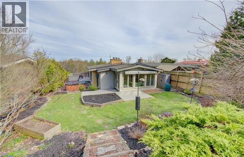 The property features an extensive yard with a lawn, a patio, and a hot tub - 400 Manchester Road, Kitchener, ON - Outdoor