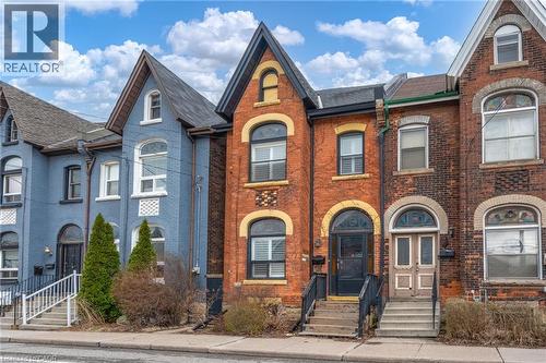 The property features a brick exterior with arched windows and a prominent gabled roofline - 198 Bay Street N, Hamilton, ON - Outdoor With Facade