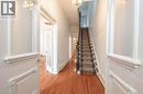 The inviting entry hall features hardwood flooring, a carpeted staircase with a dark wood banister, and an ornate white door - 198 Bay Street N, Hamilton, ON  - Indoor Photo Showing Other Room 
