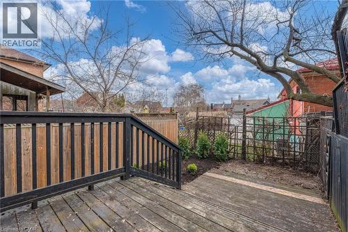 The property features a wood deck with a dark-stained railing, offering views of the yard - 198 Bay Street N, Hamilton, ON - Outdoor