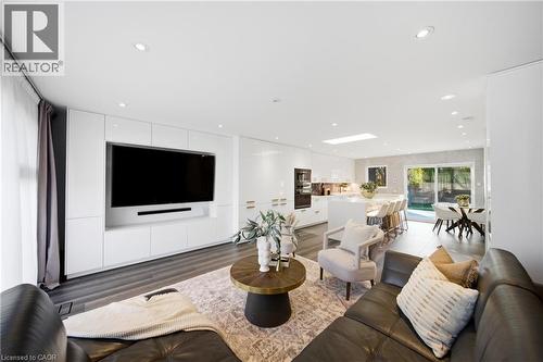 Open concept living area featuring recessed lighting, a built-in media console, dark wood flooring, and a skylight in the kitchen area - 2467 Bonner Road, Mississauga, ON - Indoor Photo Showing Living Room