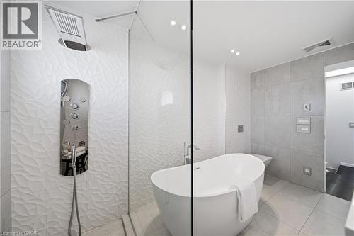 Modern bathroom featuring a freestanding tub, glass-enclosed shower, and textured wall tiles - 2467 Bonner Road, Mississauga, ON - Indoor Photo Showing Bathroom