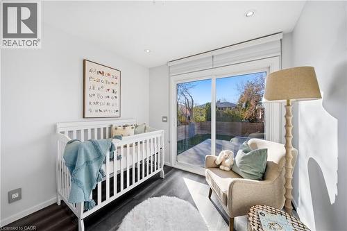 This room features dark hardwood flooring, recessed lighting, and a sliding glass door providing direct outdoor access - 2467 Bonner Road, Mississauga, ON - Indoor Photo Showing Bedroom