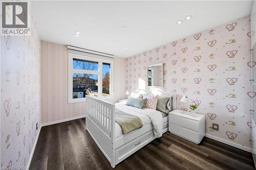 This room features dark hardwood flooring, recessed lighting, and a window with white trim - 2467 Bonner Road, Mississauga, ON - Indoor Photo Showing Bedroom