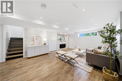 This property features wood-look flooring throughout, a recessed lighting, and a fireplace with a white brick surround - 2467 Bonner Road, Mississauga, ON - Indoor Photo Showing Other Room With Fireplace