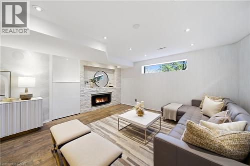 Living area featuring a modern fireplace with stone surround, recessed lighting, and a window providing natural light - 2467 Bonner Road, Mississauga, ON - Indoor Photo Showing Living Room With Fireplace