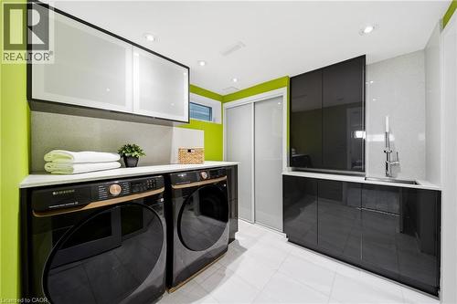 This laundry room features front-loading appliances, ample counter space, and integrated cabinetry - 2467 Bonner Road, Mississauga, ON - Indoor Photo Showing Laundry Room