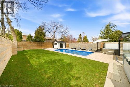 This property features a vibrant green lawn, a swimming pool with a paved surround, and a hot tub - 2467 Bonner Road, Mississauga, ON - Outdoor With In Ground Pool With Backyard