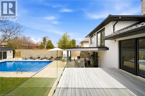 The property features an outdoor swimming pool, a spacious wooden deck, and a private patio area with an outdoor dining set - 2467 Bonner Road, Mississauga, ON - Outdoor With In Ground Pool