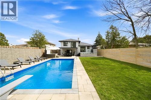 The property features a spacious backyard with a large swimming pool, a diving board, and a paved patio area - 2467 Bonner Road, Mississauga, ON - Outdoor With In Ground Pool