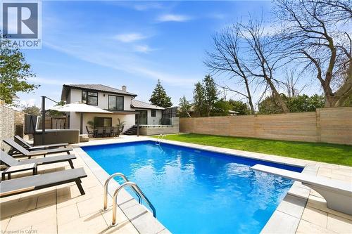The property features a spacious backyard with a swimming pool, a diving board, and a hot tub - 2467 Bonner Road, Mississauga, ON - Outdoor With In Ground Pool With Deck Patio Veranda With Backyard