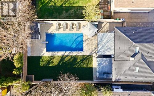 The property features a large outdoor pool with a diving board, surrounded by a paved patio area - 2467 Bonner Road, Mississauga, ON - Outdoor With In Ground Pool With Deck Patio Veranda