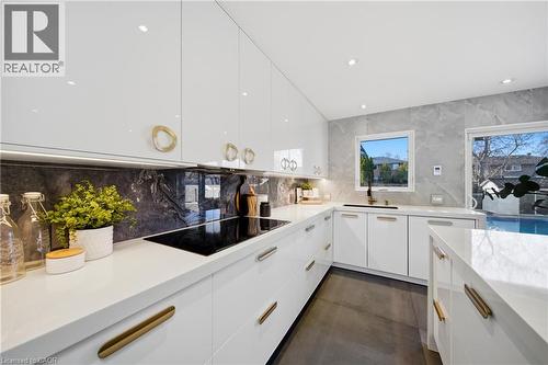 The kitchen features white cabinetry with gold-toned hardware, white countertops, and a built-in cooktop - 2467 Bonner Road, Mississauga, ON - Indoor Photo Showing Kitchen With Upgraded Kitchen