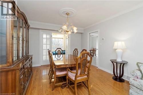 Dining area with hardwood flooring, a decorative chandelier, and white French doors - 36 Buckingham Drive, Hamilton, ON - Indoor Photo Showing Dining Room