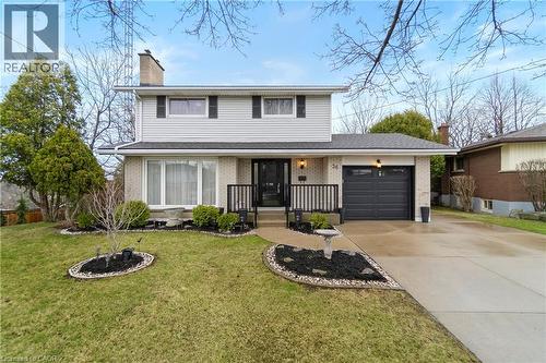 The property features a well-maintained lawn, decorative landscaping, and a paved driveway leading to an attached garage - 36 Buckingham Drive, Hamilton, ON - Outdoor