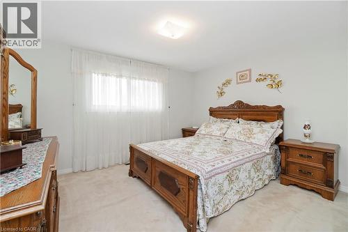 This room features light-colored carpeting, a window with sheer curtains, and a ceiling light fixture - 36 Buckingham Drive, Hamilton, ON - Indoor Photo Showing Bedroom
