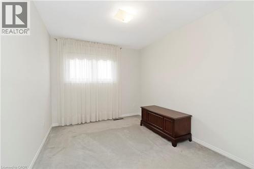 This inviting room features a window with sheer curtains, a light-colored carpet, and walls painted in a neutral tone - 36 Buckingham Drive, Hamilton, ON - Indoor Photo Showing Other Room