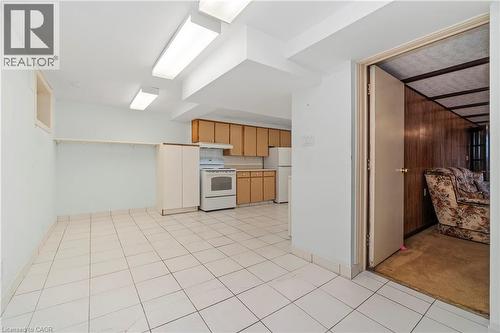This property features a kitchen area with wood cabinetry, a white stove, and a white refrigerator - 36 Buckingham Drive, Hamilton, ON - Indoor Photo Showing Kitchen