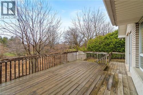 The property features an expansive wooden deck with a wooden railing, providing an outdoor space to enjoy the surrounding trees and greenery - 36 Buckingham Drive, Hamilton, ON - Outdoor With Deck Patio Veranda With Exterior