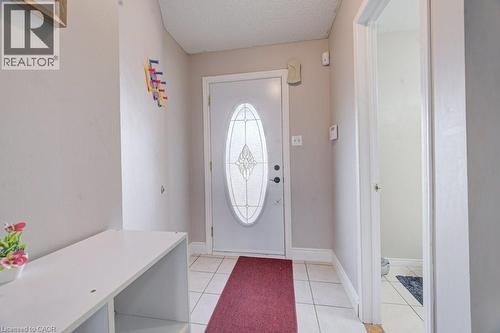 Entryway featuring a white door with an oval-shaped decorative glass insert, tiled flooring, and light-toned walls - 334 Christopher Drive, Cambridge, ON - Indoor Photo Showing Other Room