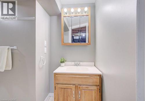 Bathroom vanity with a wood cabinet, white countertop, and a mirrored medicine cabinet above - 334 Christopher Drive, Cambridge, ON - Indoor Photo Showing Bathroom