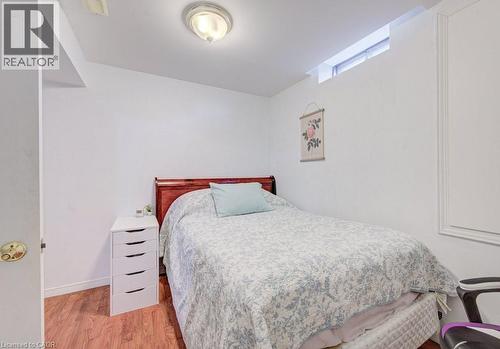 This room features white walls, rich wood-tone flooring, and a window providing natural light - 334 Christopher Drive, Cambridge, ON - Indoor Photo Showing Bedroom