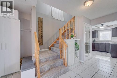 The property features a staircase with carpeted treads and wooden handrails, alongside a tiled entryway - 334 Christopher Drive, Cambridge, ON - Indoor Photo Showing Other Room