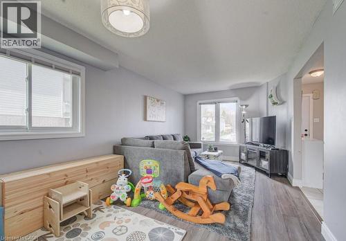 The living area features light-toned walls, windows with blinds, wood-look flooring, and a ceiling light fixture - 334 Christopher Drive, Cambridge, ON - Indoor