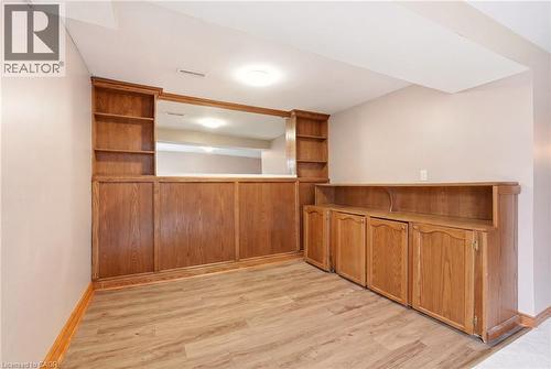 Space featuring wood-paneled walls with built-in shelving and cabinetry, and wood-style flooring - 2349 Middlesmoor Crescent, Burlington, ON - Indoor Photo Showing Other Room