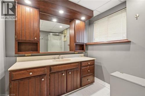 Bathroom vanity with a light-colored countertop, an integrated sink, and dark wood cabinetry with chrome fixtures - 2349 Middlesmoor Crescent, Burlington, ON - Indoor Photo Showing Bathroom