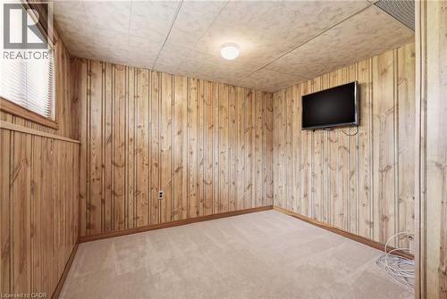 This room features carpeted flooring, wood paneling on the walls, and a window with blinds providing natural light - 2349 Middlesmoor Crescent, Burlington, ON - Indoor Photo Showing Other Room