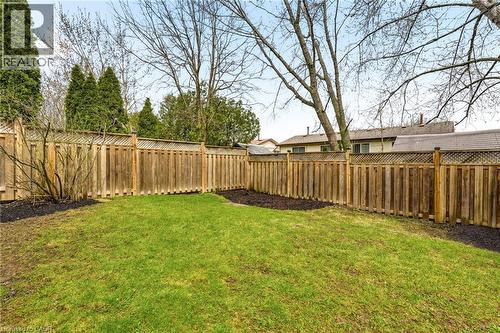 The property features an enclosed yard with a well-maintained lawn and a wooden privacy fence - 2349 Middlesmoor Crescent, Burlington, ON - Outdoor