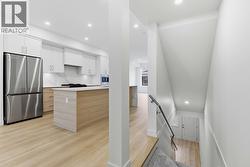 Kitchen & Stairs to Lower Level. Photo is of a similar home in the community - 