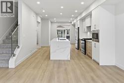 Kitchen & Stairs to Upper Level. Photo is of a similar home in the community - 