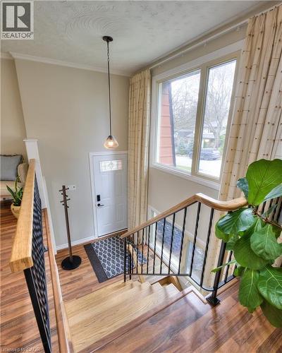 The property features a staircase with wood treads and banisters, wrought iron spindles, and views of the entryway - 42 Culpepper Drive, Waterloo, ON - Indoor Photo Showing Other Room