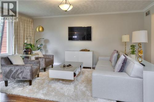 The living room features wood flooring, a central ceiling light fixture, and a large window with drapes - 42 Culpepper Drive, Waterloo, ON - Indoor Photo Showing Living Room