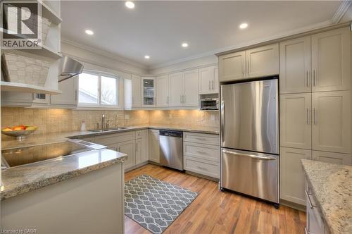 The kitchen features light-colored cabinetry, stainless steel appliances, and granite countertops - 42 Culpepper Drive, Waterloo, ON - Indoor Photo Showing Kitchen With Double Sink