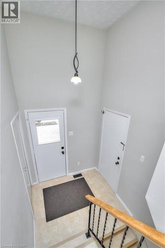 Inviting entryway featuring light-colored flooring, a white door with an upper window pane, and a decorative overhead light fixture - 42 Culpepper Drive, Waterloo, ON - Indoor Photo Showing Other Room