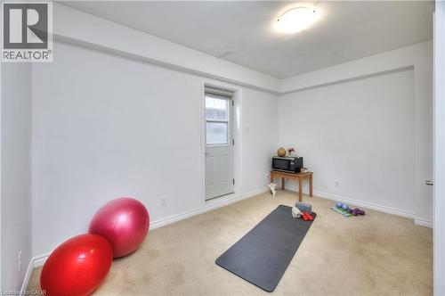 Versatile room with light-colored carpeting, white walls, and a white door with a glass pane - 42 Culpepper Drive, Waterloo, ON - Indoor