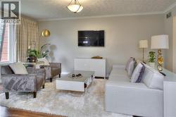 The living room features wood flooring, a central ceiling light fixture, and a large window with drapes - 